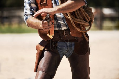 Photo for Cowboy, confrontation and aim gun to shoot for standoff or gunfight in duel for wild western culture in Texas. Male gunslinger or outlaw, revolver and tough for defense or conflict with closeup. - Royalty Free Image