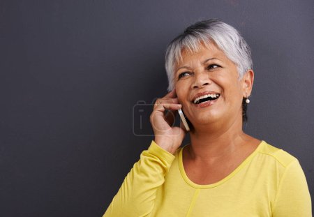 Foto de Feliz, llamada telefónica y mujer mayor en el estudio para la comunicación, buenas noticias o chismes. Contacto, maqueta y anciana mujer en conversación móvil con celular para hablar por fondo negro - Imagen libre de derechos