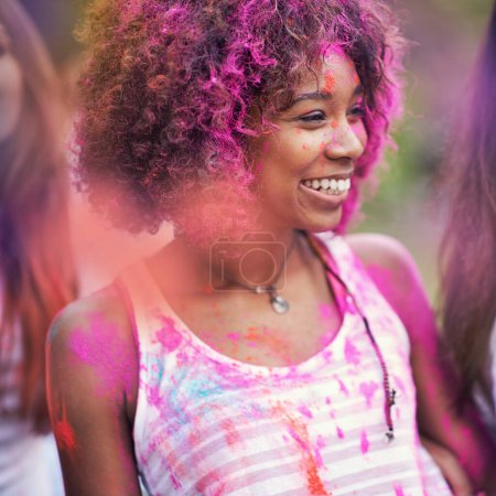 Téléchargez les photos : Poudre, peinture et femme heureuse au festival de la couleur dans le parc, plaisir avec la célébration ou la fête en plein air. Liberté, désordre excité et coloré avec sourire pour la joie et la culture, positivité et événement d'été. - en image libre de droit