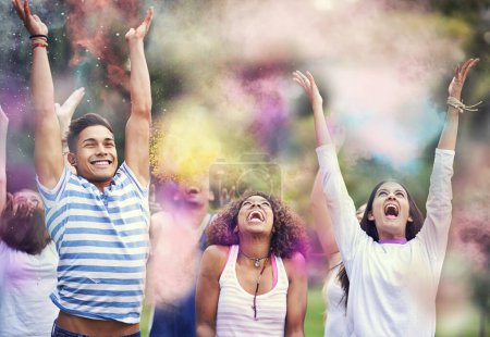 Téléchargez les photos : Poudre, peinture et amis au festival de la couleur dans le parc, le bonheur et le plaisir avec la célébration ou la fête en plein air. Liberté, désordre excité et coloré, fumée ou poussière avec positivité et les gens à l'événement d'été. - en image libre de droit