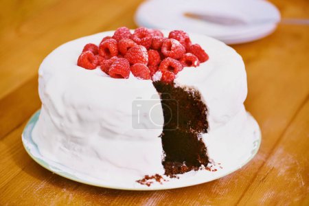 Chocolate, dessert and blackforest cake for bakery, raspberries and sweet snack for eating. Fruit, icing and plate for display on table in restaurant, creamy and baked confection with berries.