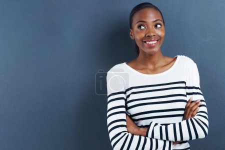 Photo for Black woman, happy and thinking in studio of fashion, inspiration and trendy by blue background. African designer, idea and arms crossed for creativity and planning a small business for funky clothes. - Royalty Free Image