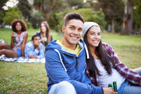 Photo for Couple, smile and portrait with beer in park with bonding and fun on campus outdoor. Students, grass and happy together in a university garden on a break on a picnic with college people with drinks. - Royalty Free Image