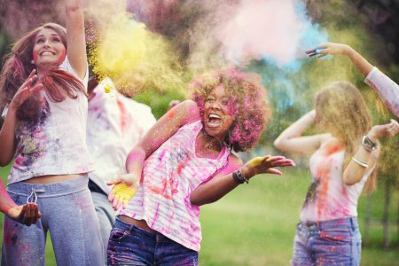 Téléchargez les photos : Amis, bonheur et peinture en poudre au festival de la couleur dans le parc, plaisir avec célébration ou fête en plein air. Liberté, liens et désordre coloré dans la nature, la joie et la culture avec les gens à l'événement d'été. - en image libre de droit
