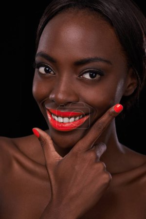 Foto de Mujer negra, lápiz labial y esmalte de uñas para la belleza con sonrisa, cosméticos y maquillaje brillante sobre fondo oscuro. Bálsamo labial audaz, vibrante y naranja con manicura, cosmetología y glamour en estudio. - Imagen libre de derechos