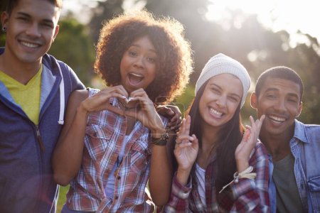 Photo for Portrait, smile and diverse friends in nature, outdoors or garden with excited expression. Social, joy or happy with hand heart emoji from group of student, summer and sunset with lens flare outside. - Royalty Free Image