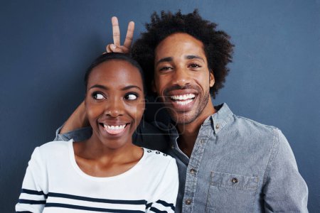Photo for Happy, portrait and black couple with peace and love on studio background together with happiness. Crazy, face and sign for bunny ears in silly profile picture of people with casual fashion or style. - Royalty Free Image