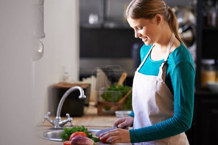 Photo for Nutrition, cooking and woman with ingredients in kitchen cutting vegetables with knife at home. Happy, groceries and female person with organic produce for dinner, supper or meal at apartment - Royalty Free Image