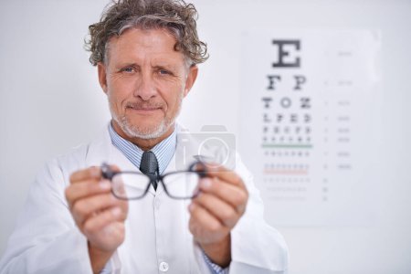 Photo for Glasses, test and portrait of optometrist in clinic to check vision and eye exam in healthcare. Mature, doctor and reading letters on wall in medical assessment or consultation for contact lenses. - Royalty Free Image