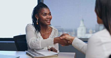 Photo for Business, woman and handshake in job interview for welcome to meeting with smile, hr and thank you in office. African employee, client and shaking hands with documents for hiring deal and recruitment. - Royalty Free Image