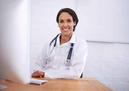 Photo for Portrait, doctor and happy woman at desk in hospital for healthcare, wellness or working online on computer. Face, smile or medical expert at table, professional or employee with confidence in clinic. - Royalty Free Image