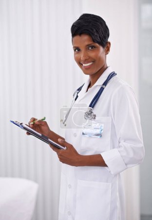 Photo for Portrait, doctor and happy woman writing on checklist in hospital for healthcare career in India. Face, smile and medical professional with clipboard, employee or expert worker in clinic for wellness. - Royalty Free Image