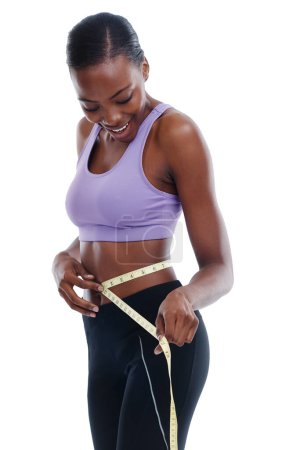 Téléchargez les photos : Fitness, ruban à mesurer et la taille avec une femme noire heureuse en studio isolé sur fond blanc pour la perte de poids. Exercice, sourire et alimentation avec de jeunes modèles d'entraînement sportif pour la santé ou la nutrition. - en image libre de droit