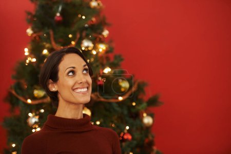 Photo for Christmas, thinking and woman in home with tree for festive holiday and planning decoration on vacation. Happy, girl or excited for xmas in winter and idea for house on red background in mockup space. - Royalty Free Image
