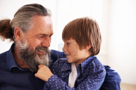 Photo for Smile, grandfather and boy with beard and playing, bonding and relax in living room. Happy family, play and fun with grandpa and pulling facial hair, embrace and caring cuddle with love in lounge. - Royalty Free Image