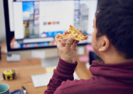 Businessman, eating and lunch with computer screen in office with rear view and pizza break for working on deadline. Programmer, employee and back with fast food, coding display or hungry at desk.