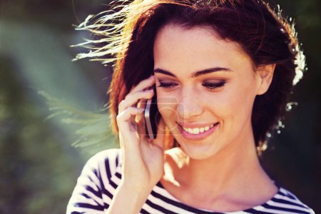 Photo for Woman, smile and phone call with communication outdoor for conversation, networking and mobile chat with sunlight. Person, happy and smartphone in nature for talking, discussion and listening in wind. - Royalty Free Image