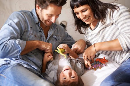 Téléchargez les photos : Heureux, la famille et l'enfant jouent dans le salon ensemble pour créer des liens, s'amuser et se divertir à la maison. Développement de l'enfance, Australien homme et femme avec enfant pour rire, blague et jouets. - en image libre de droit