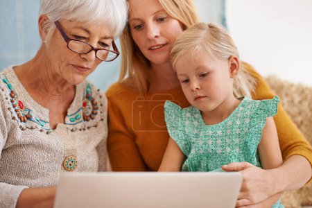 Photo for Family, laptop and internet at a home with grandmother, girl and mother together with game. Learning, online and senior woman with child and mom with love, support and care in a house with tech. - Royalty Free Image