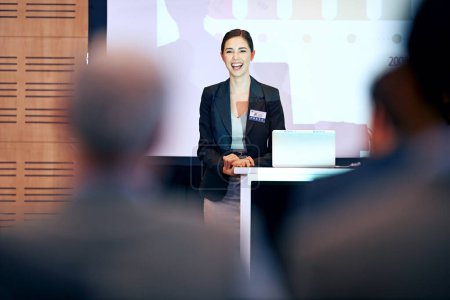 Photo for Business, happy woman at podium and presentation with projector screen, conference or workshop with laptop for PPT. Corporate training, seminar and speaker with audience for professional speech. - Royalty Free Image