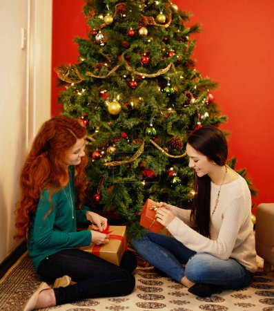 Photo for Christmas, happy and women with presents, tree with decor in living room for holiday. Gift giving, smile and family sitting on floor together, Christian celebration on Xmas eve with mother and child. - Royalty Free Image