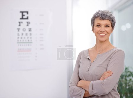 Photo for Woman, smile and portrait of optometrist in office with confidence, eye exam and medical test. Healthcare, mature employee and happy with sight support, wellness and chart for vision assessment. - Royalty Free Image