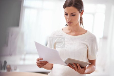 Photo for Businesswoman reading, paperwork and tablet in office or technology, online documents with serious person. Entrepreneur, creative business planning and internet, social media website and browsing. - Royalty Free Image