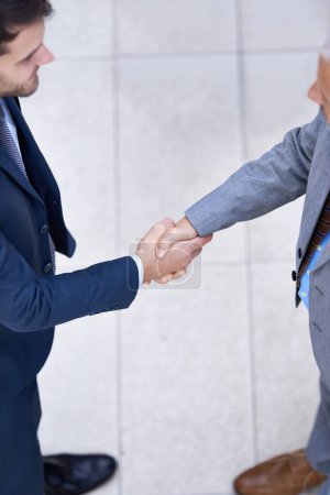 Photo for Above, business people and shaking hands for deal, collaboration or b2b partnership agreement for consultant. Top view, introduction and handshake of team for greeting, thank you or welcome to office. - Royalty Free Image