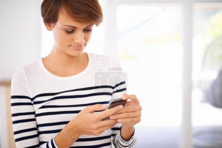 Photo for Phone, smile and woman in living room networking on social media, mobile app or internet. Happy, technology and female person reading blog on website with cellphone in lounge at modern apartment - Royalty Free Image