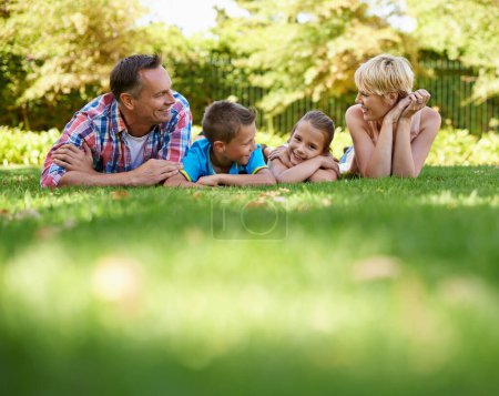 Téléchargez les photos : Jardin, parc et famille heureuse se détendre sur l'herbe en été ou les parents et les enfants ensemble. Mère, père et enfants sourient dans la cour en vacances ou en vacances dans la forêt, les bois ou profiter du soleil dans la nature. - en image libre de droit