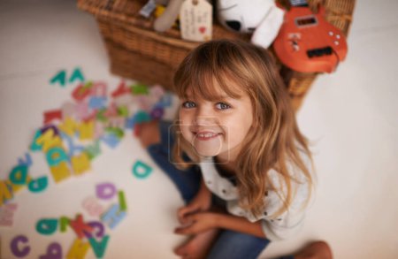 Photo for Girl, child and smile with letter toys for learning, development and games in playroom at home. Portrait, education and growth in childhood with alphabet, language and happy kid playing for fun. - Royalty Free Image
