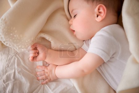 Photo for Baby, sleeping and tired at home with relax, nap and nursery with peace in a bed with blanket. Morning, youth and kid with dream of an infant with child development from rest in bedroom with newborn. - Royalty Free Image
