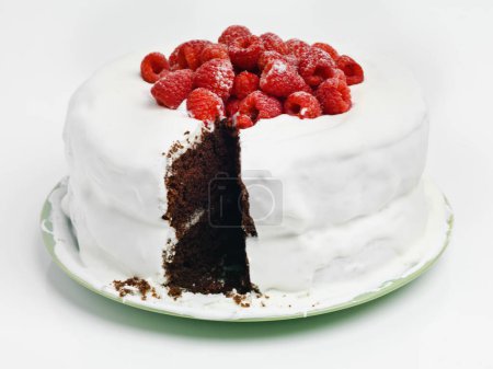 Chocolate, dessert and blackforest cake for bakery, slice and raspberries for sweet snack. Fruit, icing and plate for display on table in pastry restaurant, creamy and baked confection with berries.