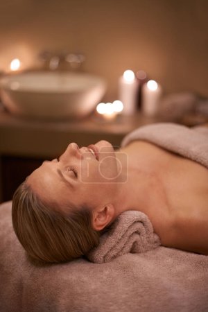 Photo for Blonde woman, massage therapy and candlelight for wellness, smile and relaxation to destress and pamper. Female person, self care and cleanse for detox, spa day and peace for beauty and happiness. - Royalty Free Image