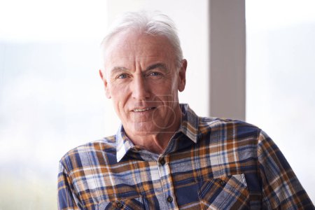 Photo for Portrait, retirement and senior man in home to relax in apartment alone by window in Australia. Face, elderly and male person with confidence or handsome pensioner in casual clothes at nursing house. - Royalty Free Image