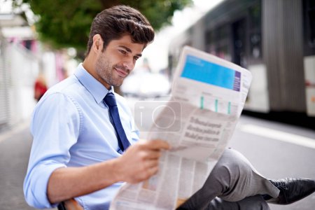 Photo for Professional, businessman and reading newspaper for information, daily news and updates on local events. Outdoors, male person and smile with article for stories, journalism and newsletter in city. - Royalty Free Image