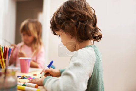 Photo for Child, writing and drawing with colorful art at home for learning, education or creativity. Young boy with color pencil for sketching, activity or artwork in early childhood development at the house. - Royalty Free Image