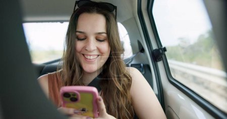 Photo for Happy woman, phone and social media in car for travel, communication or networking in transportation. Female person smile on mobile smartphone in vehicle for online chatting, texting or road trip. - Royalty Free Image