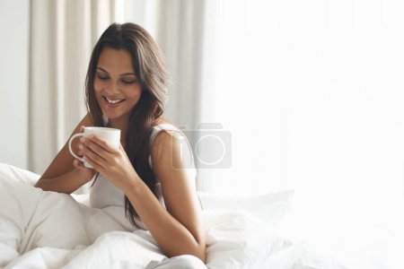 Photo for Happy, calm and woman with coffee in bedroom with caffeine to wake up in morning at home. Smile, relax and comfy young female person drinking mug of cappuccino, espresso or latte in apartment - Royalty Free Image