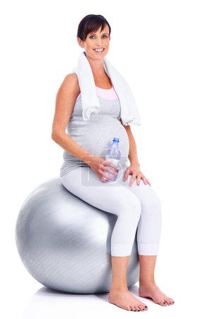 Téléchargez les photos : Femme enceinte, fitness et ballon pour studio, bien-être et exercice pour la maternité pendant la grossesse. Femme maternelle, eau et fond blanc pour la santé, maternité et serviette pour garder la forme. - en image libre de droit