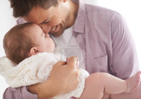 Téléchargez les photos : Bébé, fille et papa tenant avec sourire, fier et jour des pères dans la maison familiale. Les parents, le nourrisson et l'amour embrassent pour baiser eskimo, la croissance et le développement sain de l'enfant en pépinière pour l'affection parentale. - en image libre de droit