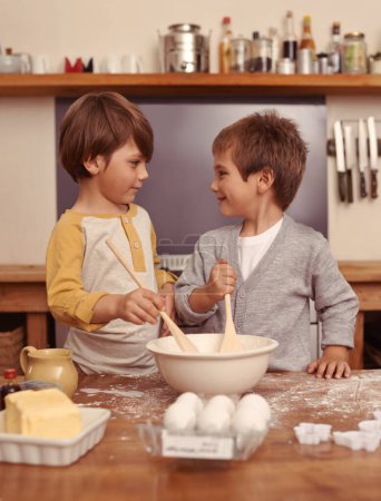 Photo for Boys, baking and together in kitchen with flour, home and bonding with ingredients for dessert cake. Children, mixing and bowl for cookies on counter, eggs and learning of pastry recipe with butter. - Royalty Free Image