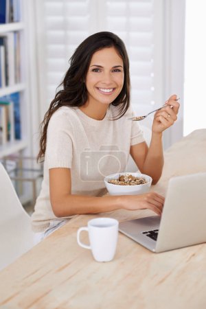 Photo for Woman, breakfast and cereal with laptop remote work from home in portrait with smile for healthy meal. Person, freelance writer and eating for diet, nutrition or computer at table in morning at house. - Royalty Free Image