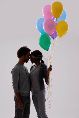 Photo for Couple, silhouette and love with party balloons for celebration, event or romance on a gray studio background. Man and woman with colorful blowups of helium for date or anniversary on mockup space. - Royalty Free Image