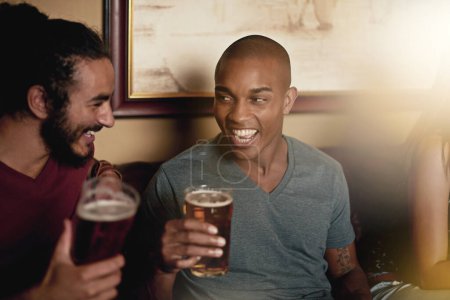 Photo for Talking, happy friends and drinking beer in pub at party, celebration and laughing at funny joke together at club. Smile, diverse group and people with alcohol in glass at bar for social gathering. - Royalty Free Image