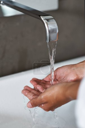Téléchargez les photos : Lavage des mains, eau et personne dans la salle de bain pour l'hygiène, le bien-être et la sécurité contre les germes ou les bactéries à la maison. Nettoyage des mains, liquide et auto-soin avec soin de la peau, désinfection et éclaboussure dans l'évier. - en image libre de droit