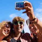 Friends, group and selfie outdoor for festival, photography and digital camera for portrait. Music, people and blue sky in summer, together and happy with culture of music in carnival and smile.