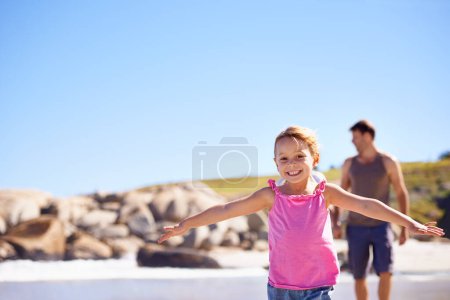 Téléchargez les photos : Heureux, portrait et petite fille volant sur la plage avec un ciel bleu pour s'amuser été, vacances ou week-end en plein air dans la nature. Femme, enfant ou enfant avec le sourire pour une journée ludique au bord de l'océan sur maquette. - en image libre de droit