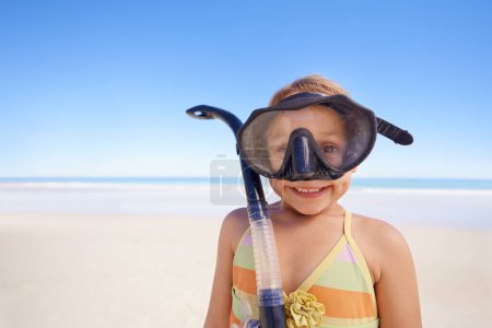 Foto de Chica, retrato y gafas para bucear en la playa, sonrisa y equipo para nadar de vacaciones. Persona femenina, niño y viajar en vacaciones tropicales en el aire libre, arena y cielo azul para el espacio de la maqueta. - Imagen libre de derechos