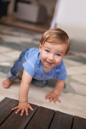 Téléchargez les photos : Plancher, ramper et portrait de bébé à la maison pour le plaisir de jouer, le bonheur et l'apprentissage seul sur le terrain. Détendez-vous, garçon et visage d'un tout-petit avec le sourire pour le développement de l'enfant, le bien-être ou la croissance dans une maison. - en image libre de droit